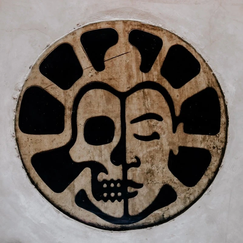 The REWILD YOGA split-face medallion set into worn concrete.