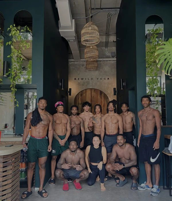 Ohio University football players gathered in the REWILD YOGA lobby beneath hanging lights and beside living plants.