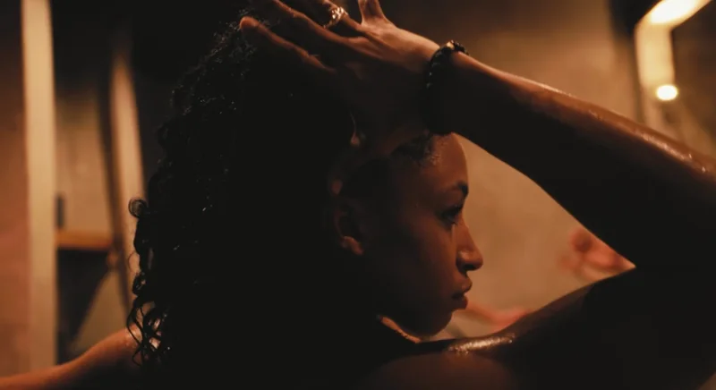 Arms and hands around locked hair in a close view of practice.